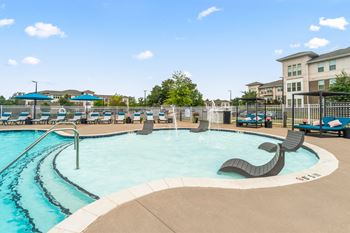 Resort style pool with lounge chairs on in-water ledge